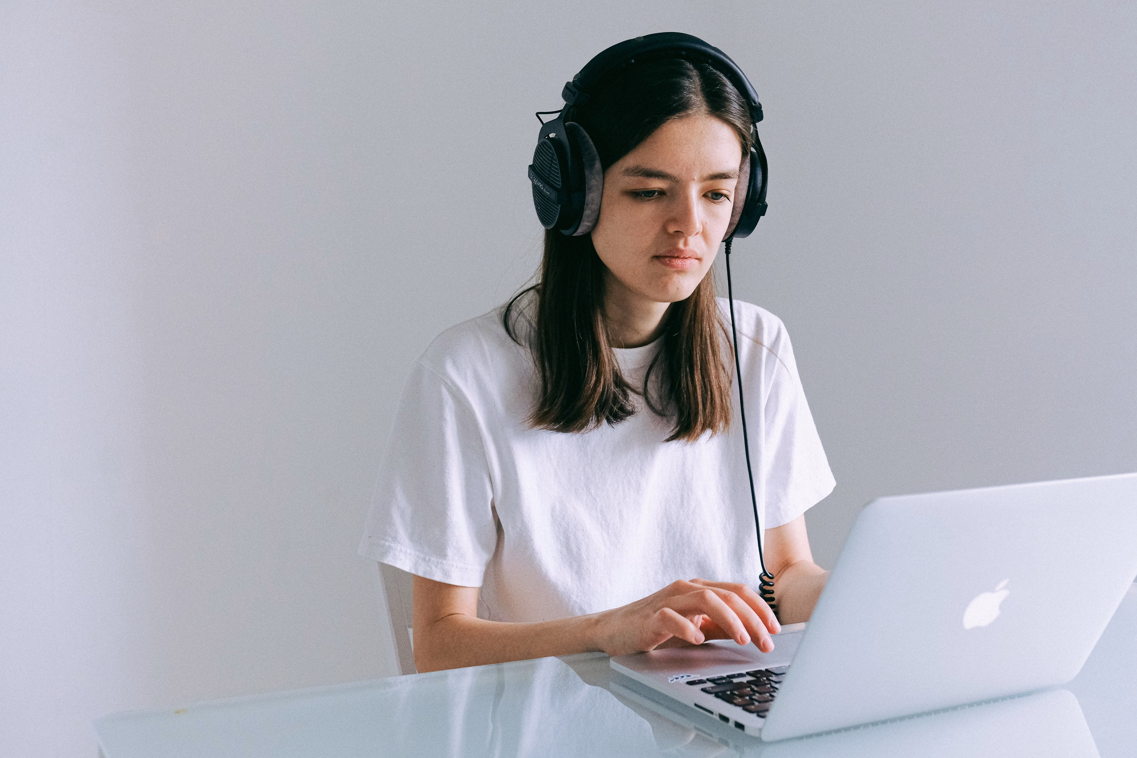 Woman working on her laptop with headphones in a quiet home office