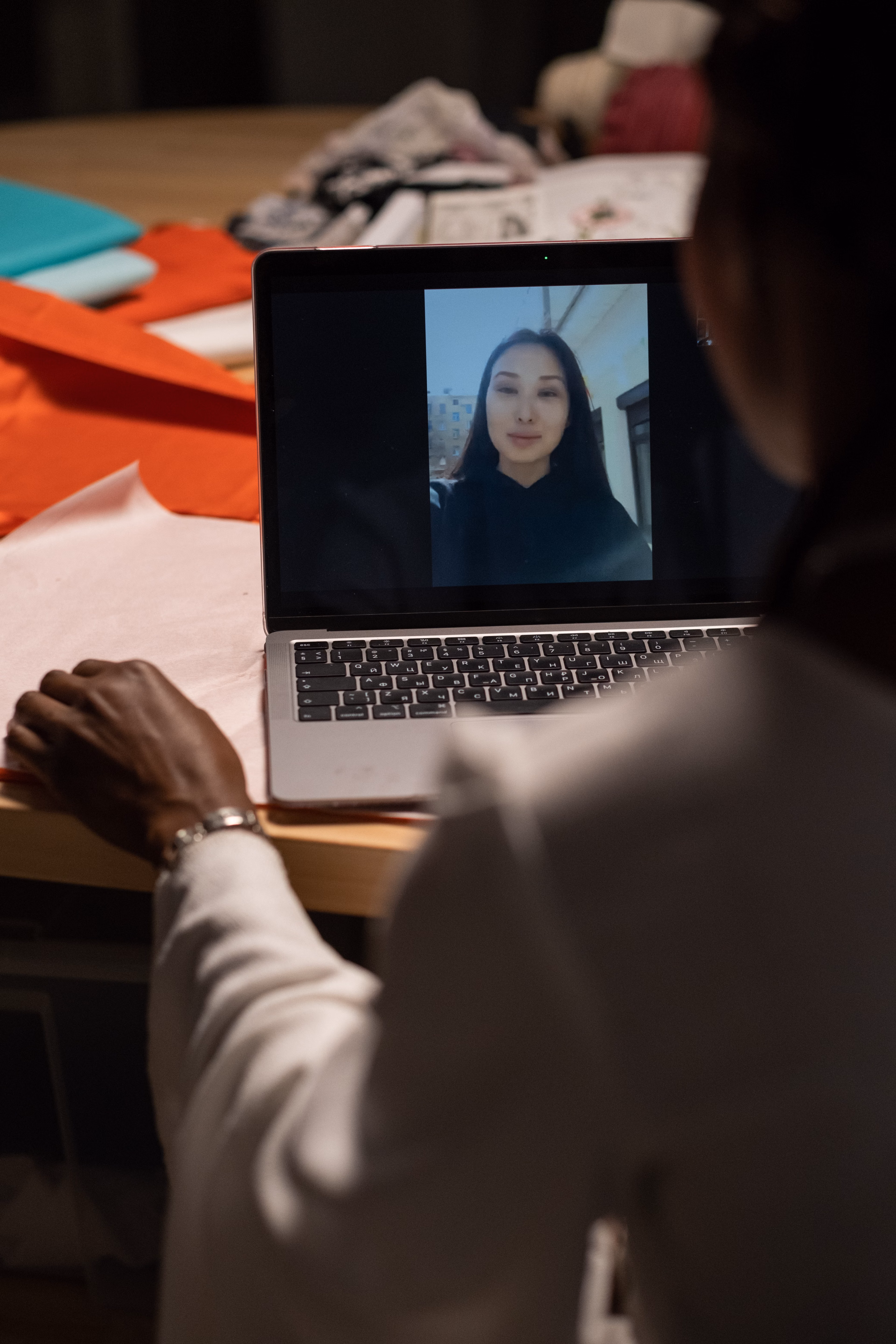 Woman in a creative workspace on a video call with a colleague on a laptop