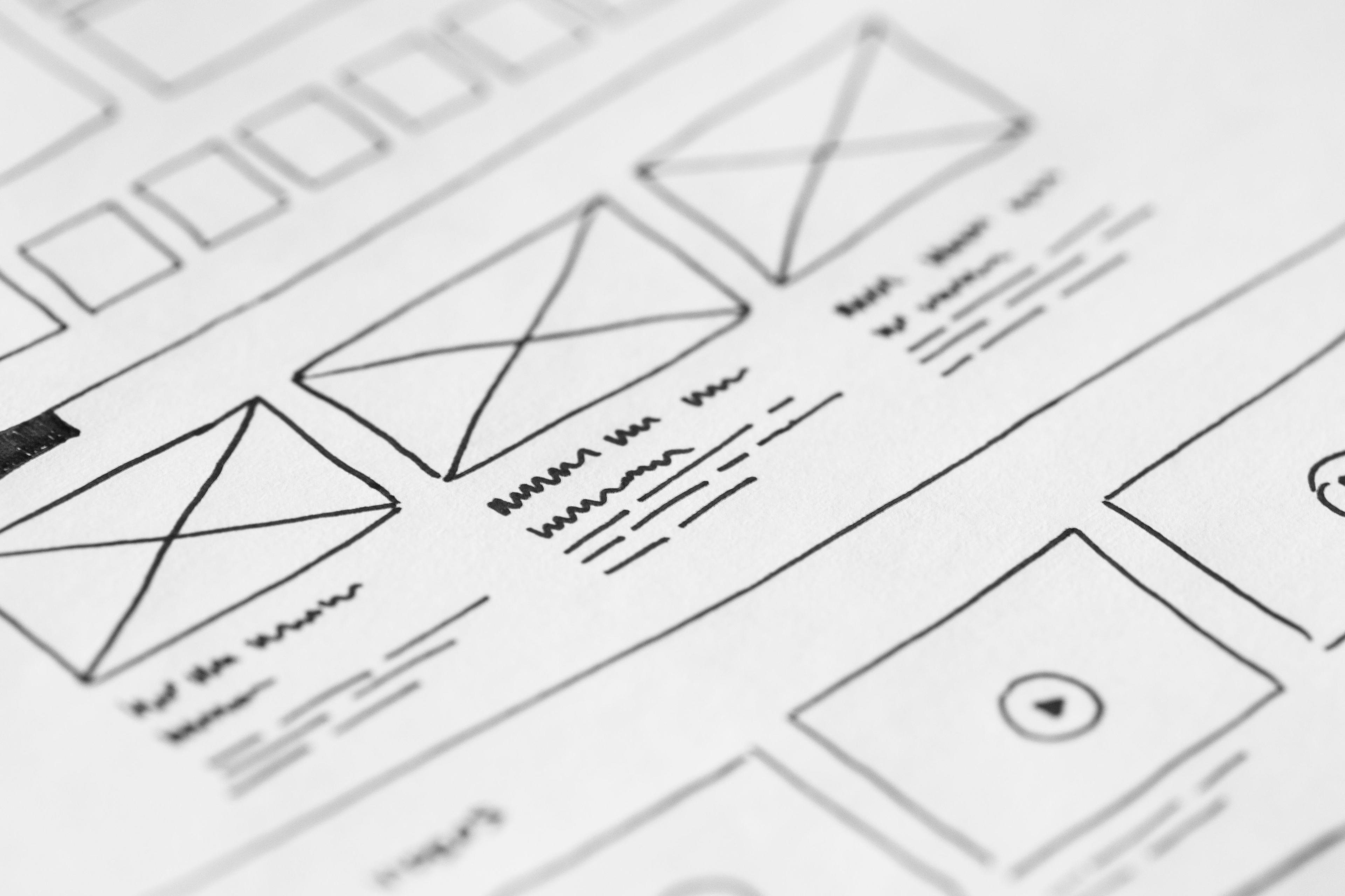 Blank white paper on a wooden desk ready for wireframing