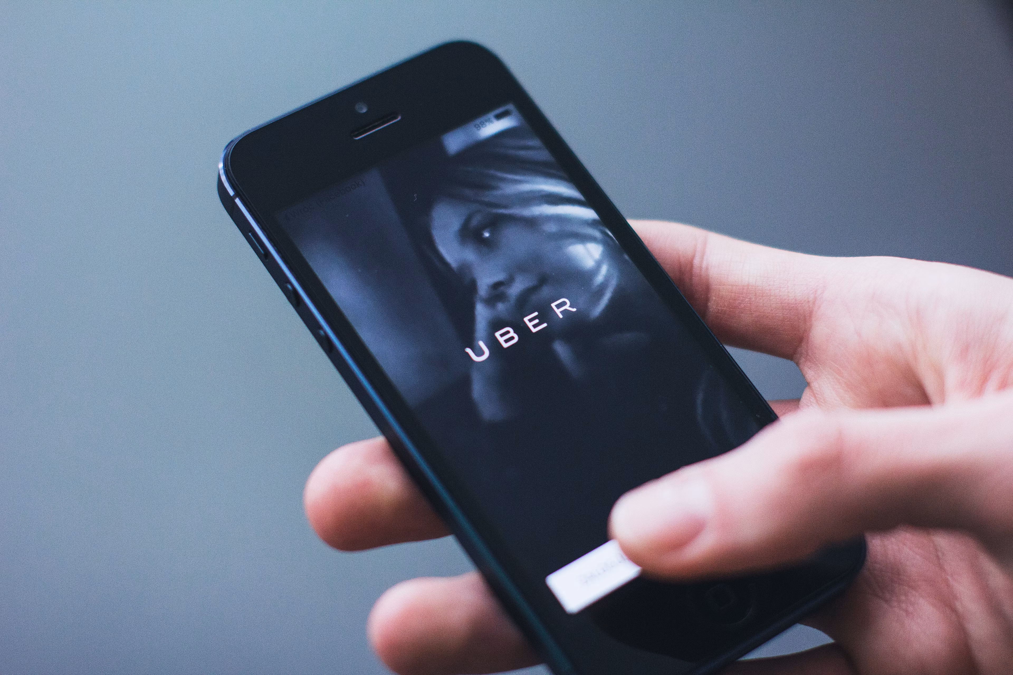 Person holding a smartphone with the Uber app open on the screen