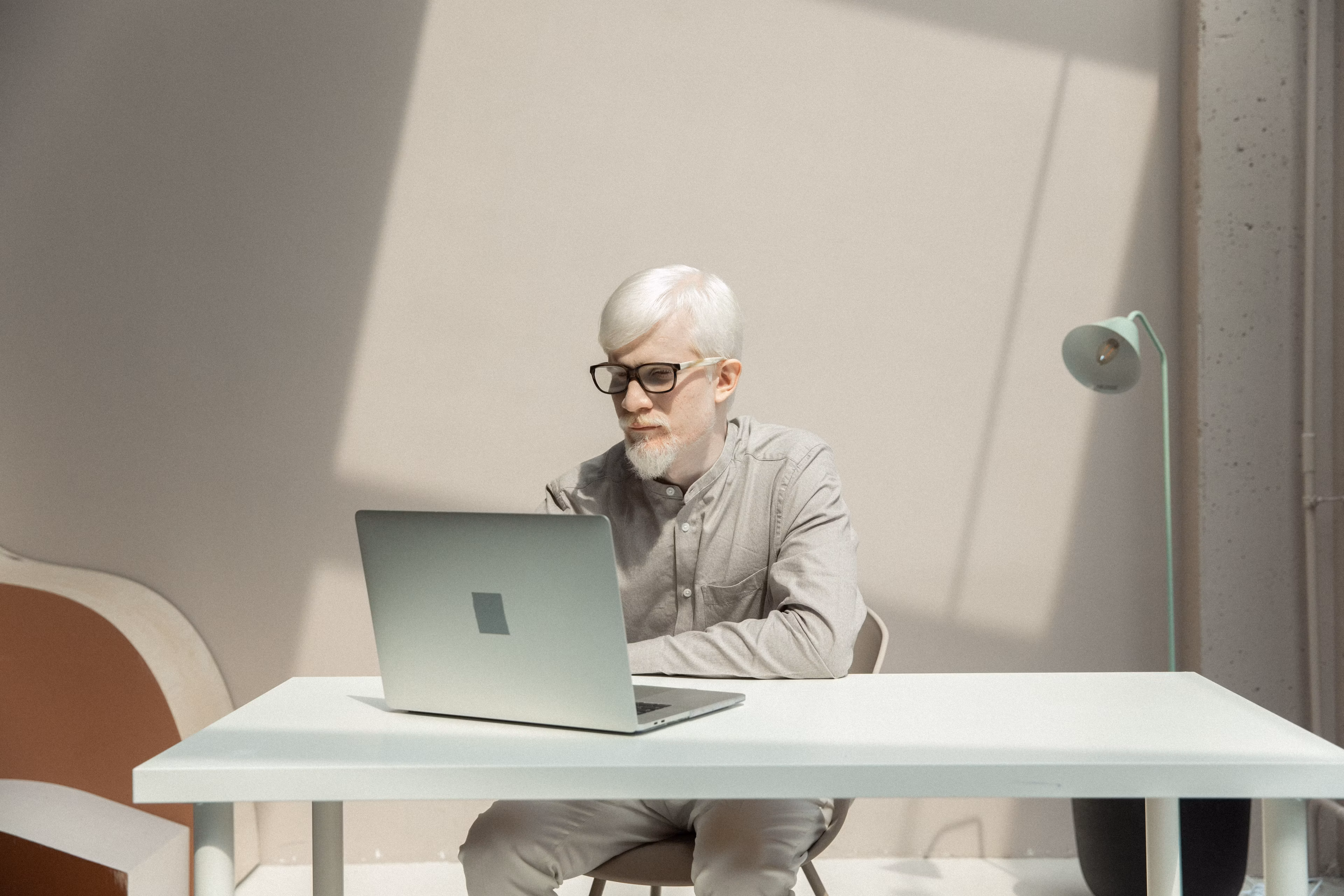 Professional working on laptop at a table in an office environment