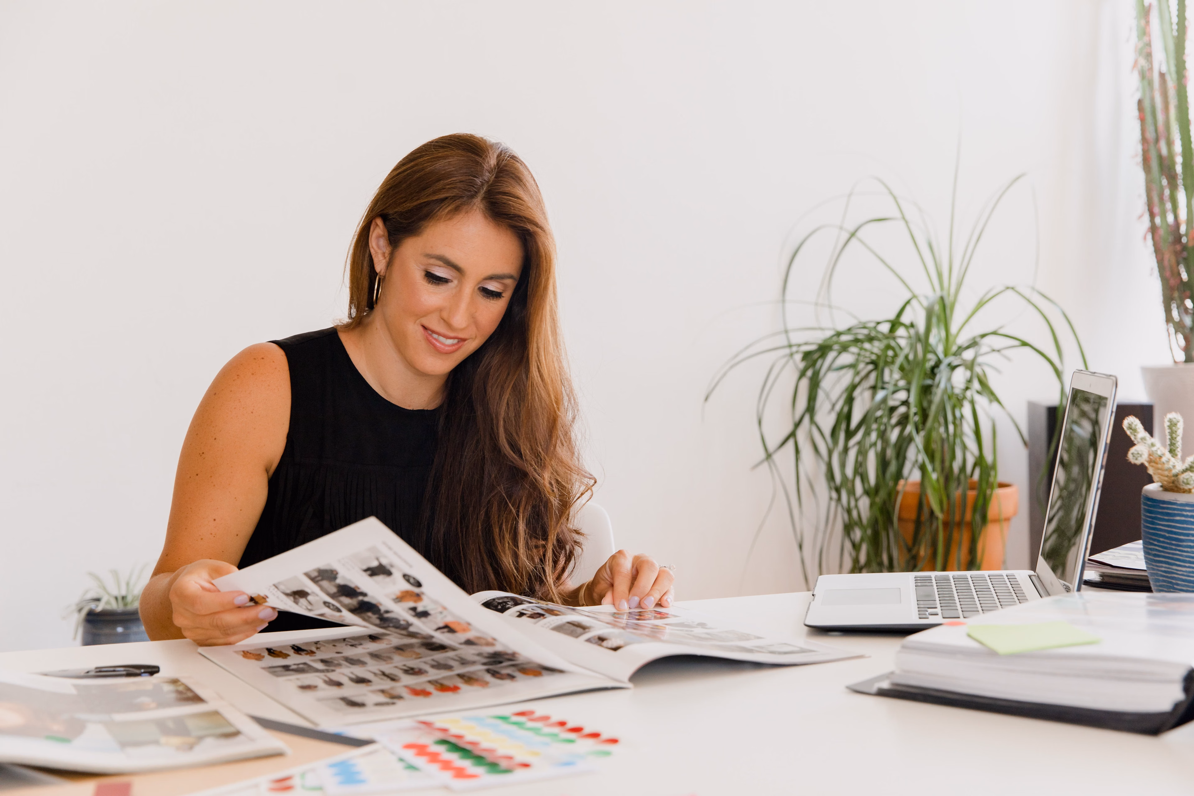 Businesswoman reviewing a design portfolio at a desk in a modern office